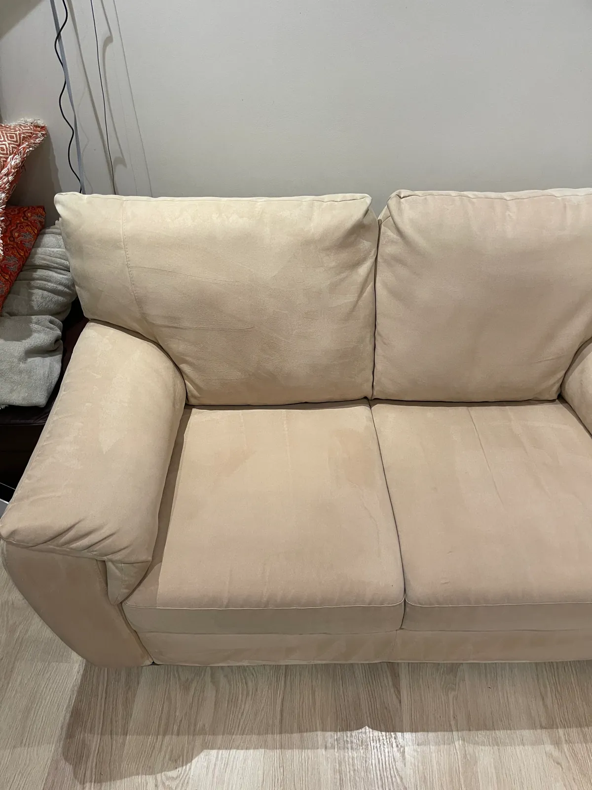 The same pale fabric sofa after cleaning, with fewer visible marks