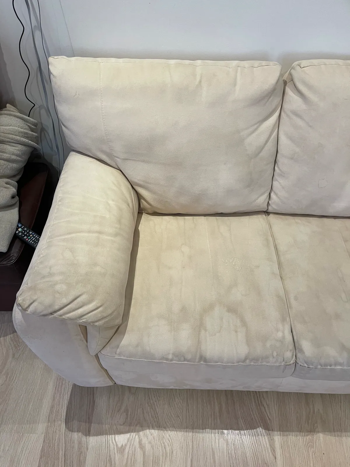 Pale fabric sofa with visible everyday marks before cleaning