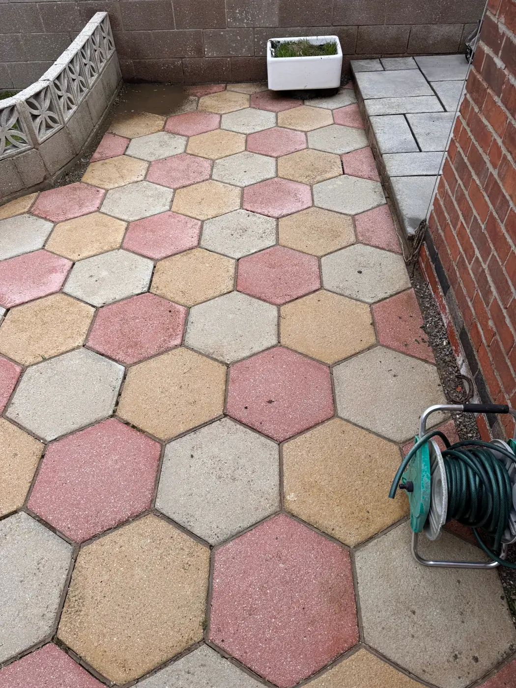 Hexagonal patio paving facing the boundary wall after cleaning