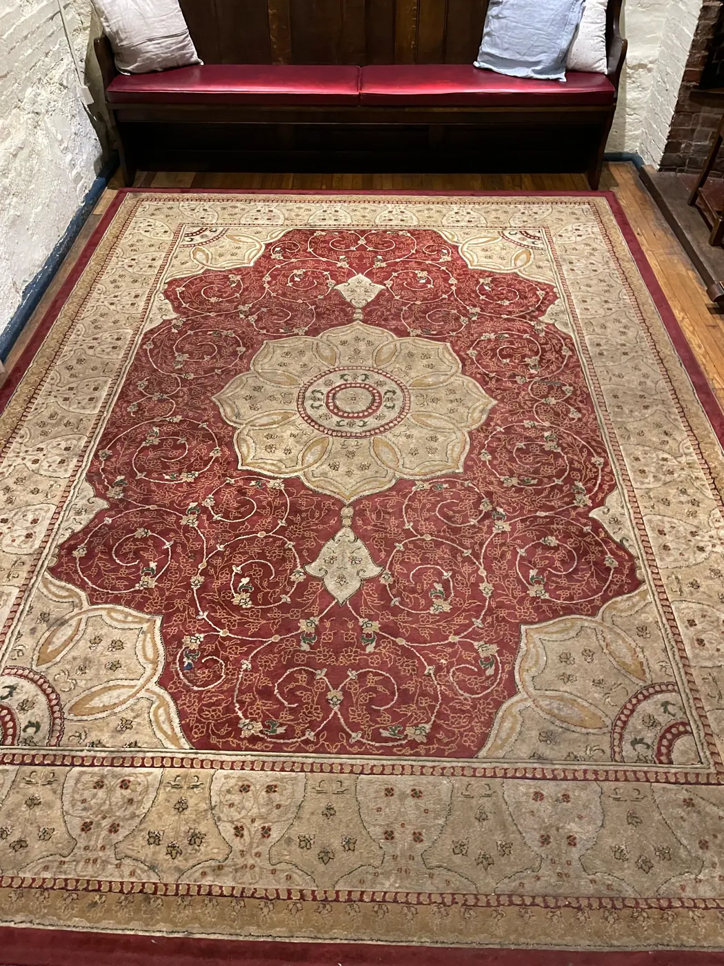 Detailed red and cream rug before cleaning