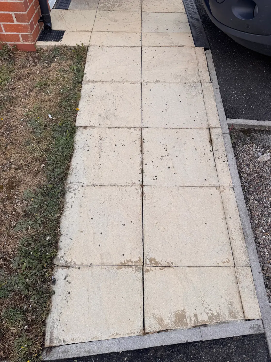 Paving slabs beside a brick house after cleaning