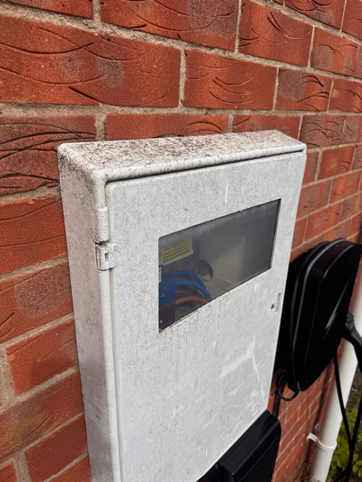 Exterior meter box with a glass window before cleaning